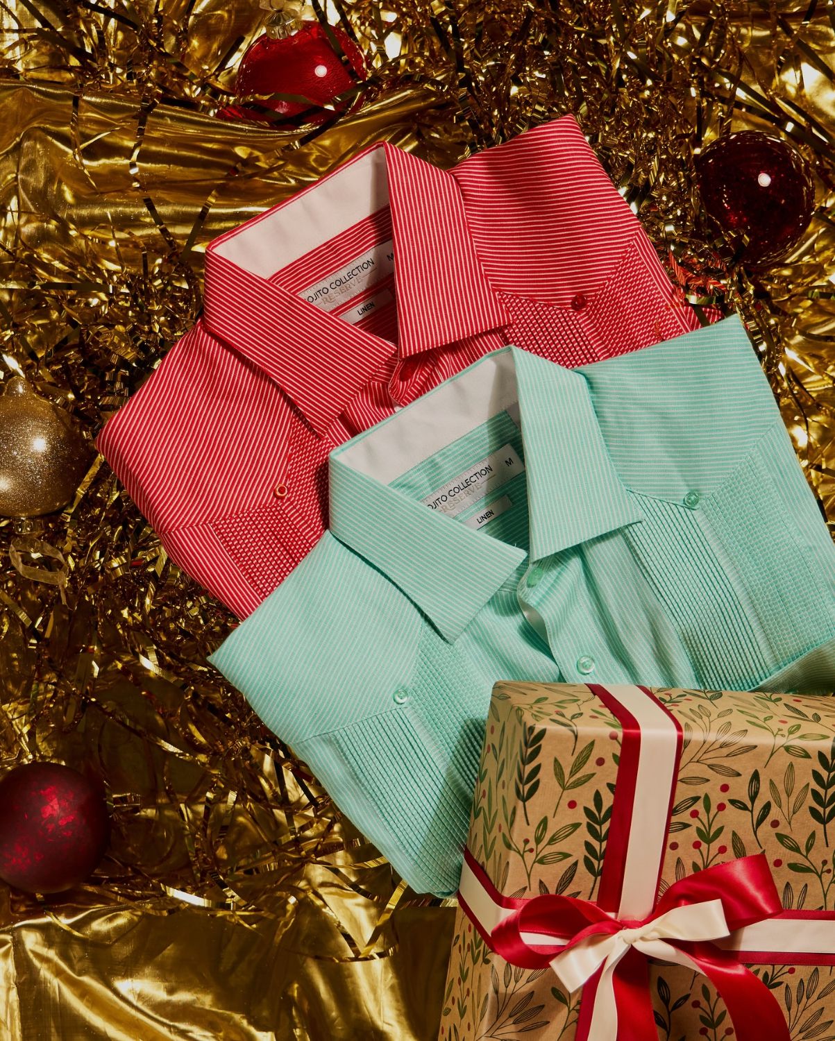 Red and mint striped linen guayaberas folded together with a wrapped Christmas present
