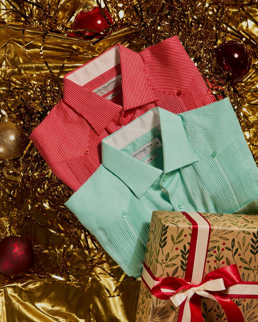Red and mint striped linen guayaberas folded together with a wrapped Christmas present