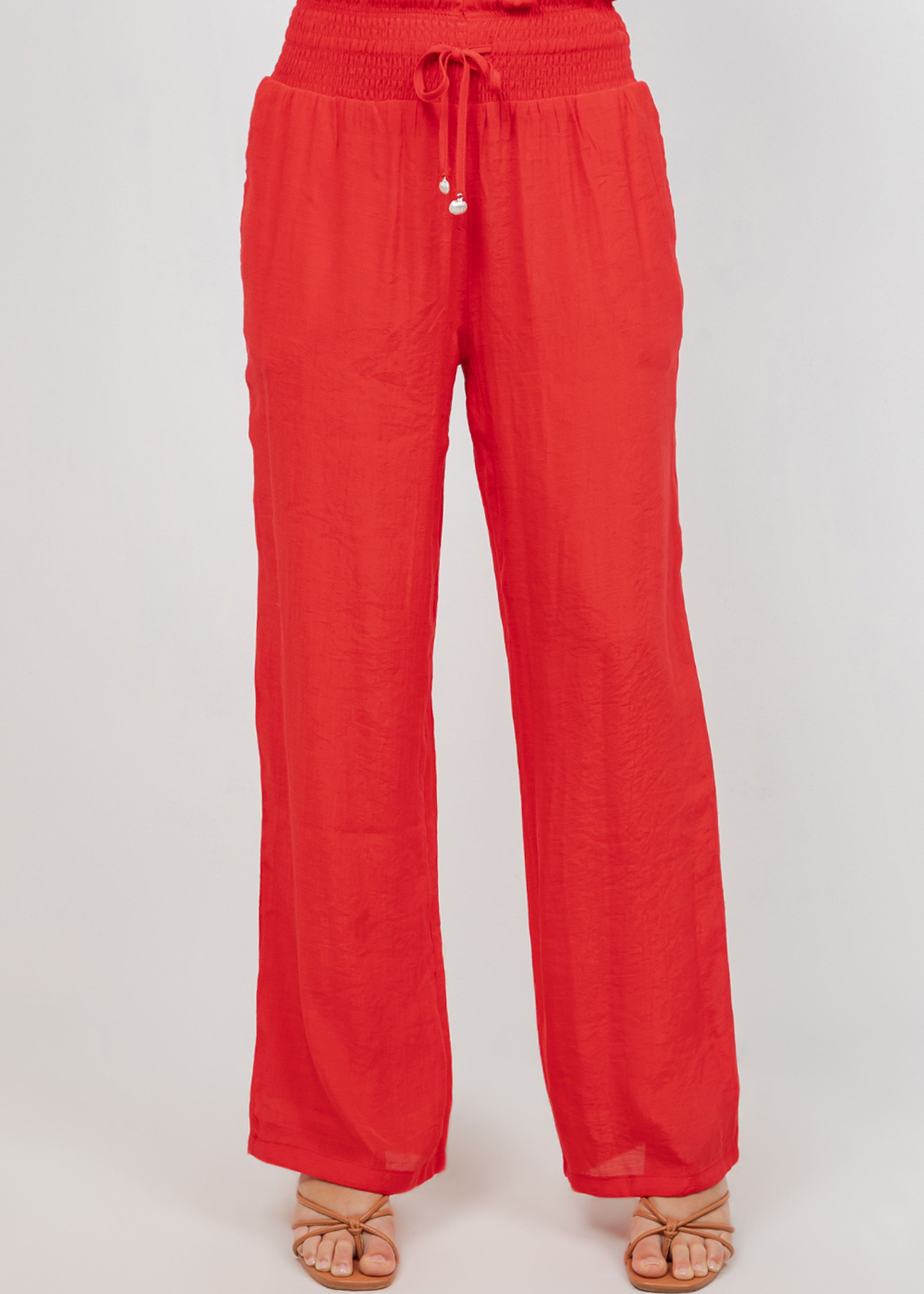 Front view of red Ladies Smocked Waist Drawstring Palazzo Pants featuring a smocked waist and wide legs.