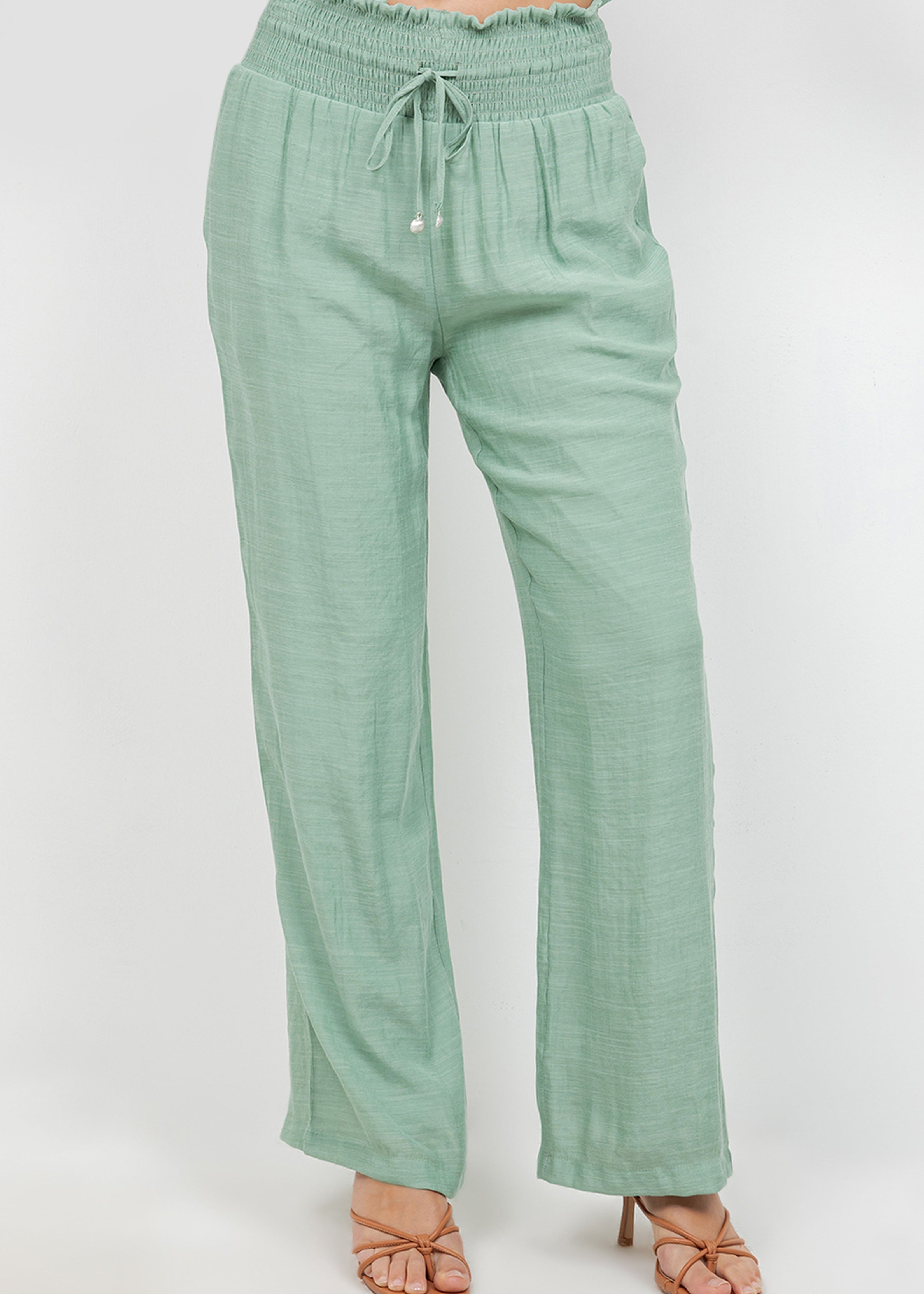 Front view of Ladies Smocked Waist Drawstring Palazzo Pants in light green with a smocked waist and wide legs.