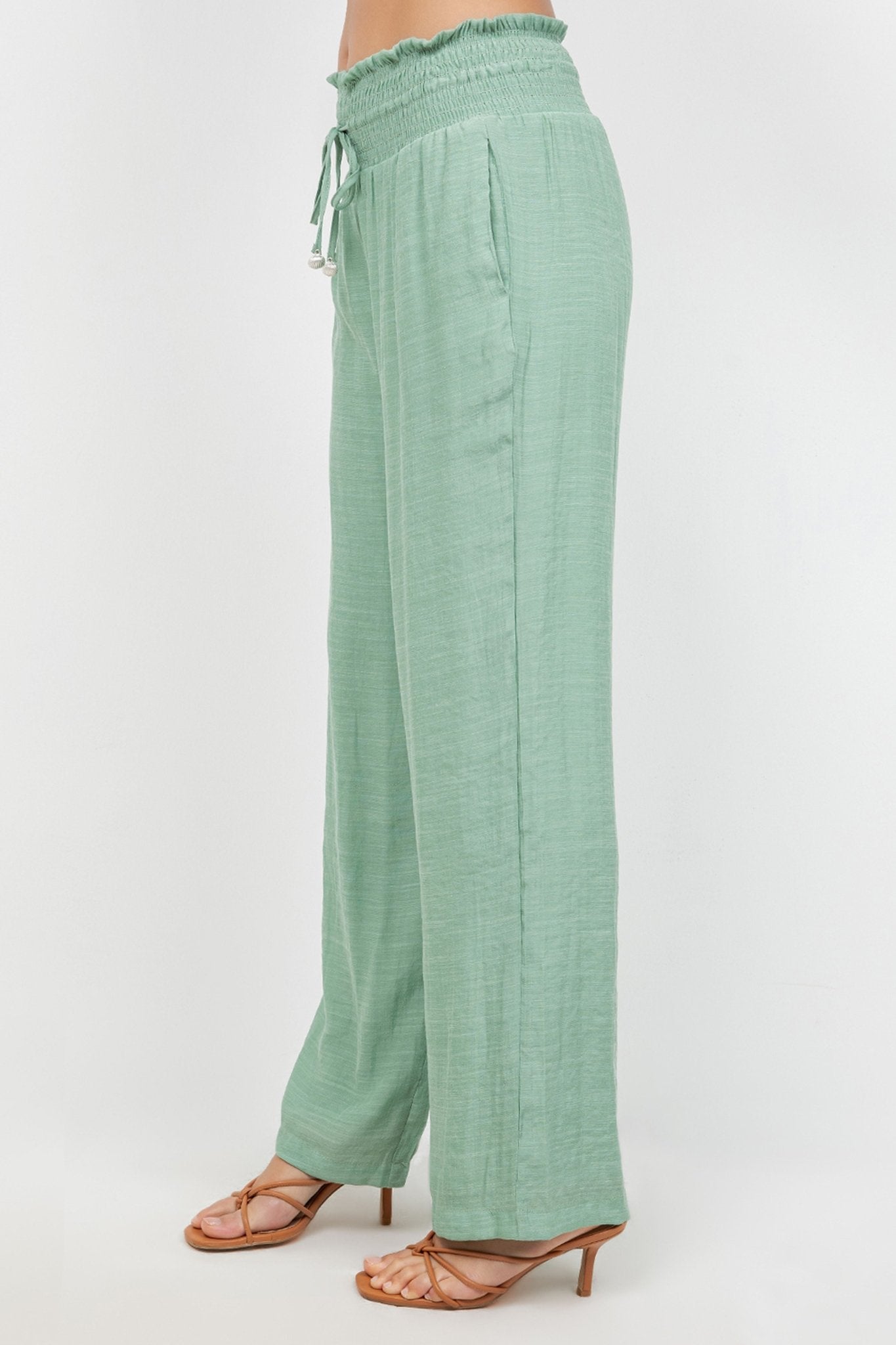 Side view of light green Ladies Smocked Waist Drawstring Palazzo Pants with a visible drawstring and smocked waist.