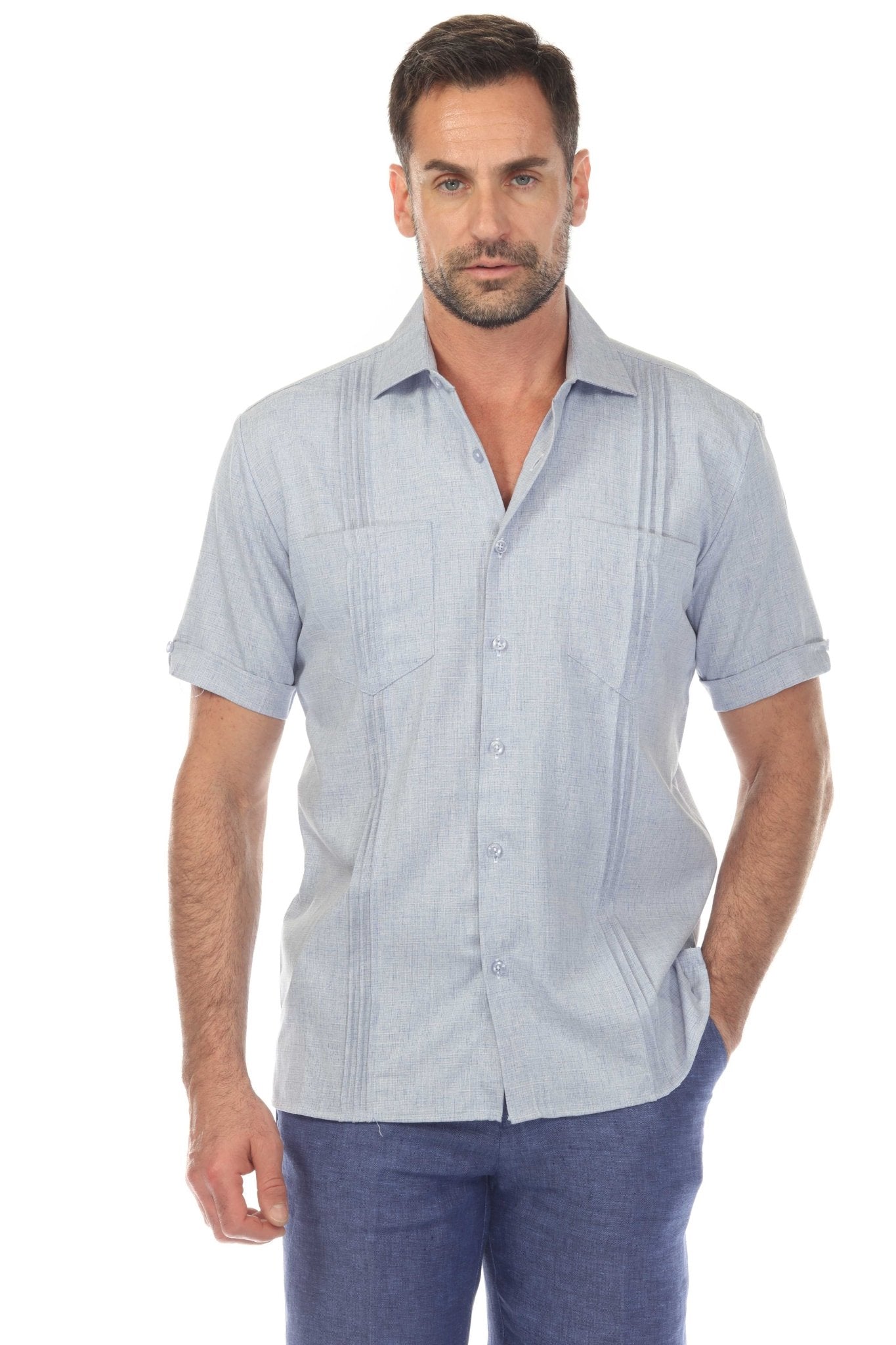 A man wears a light blue Men’s Classic Two-Pocket Guayamisa Shirt with Pleats, shown from the front.