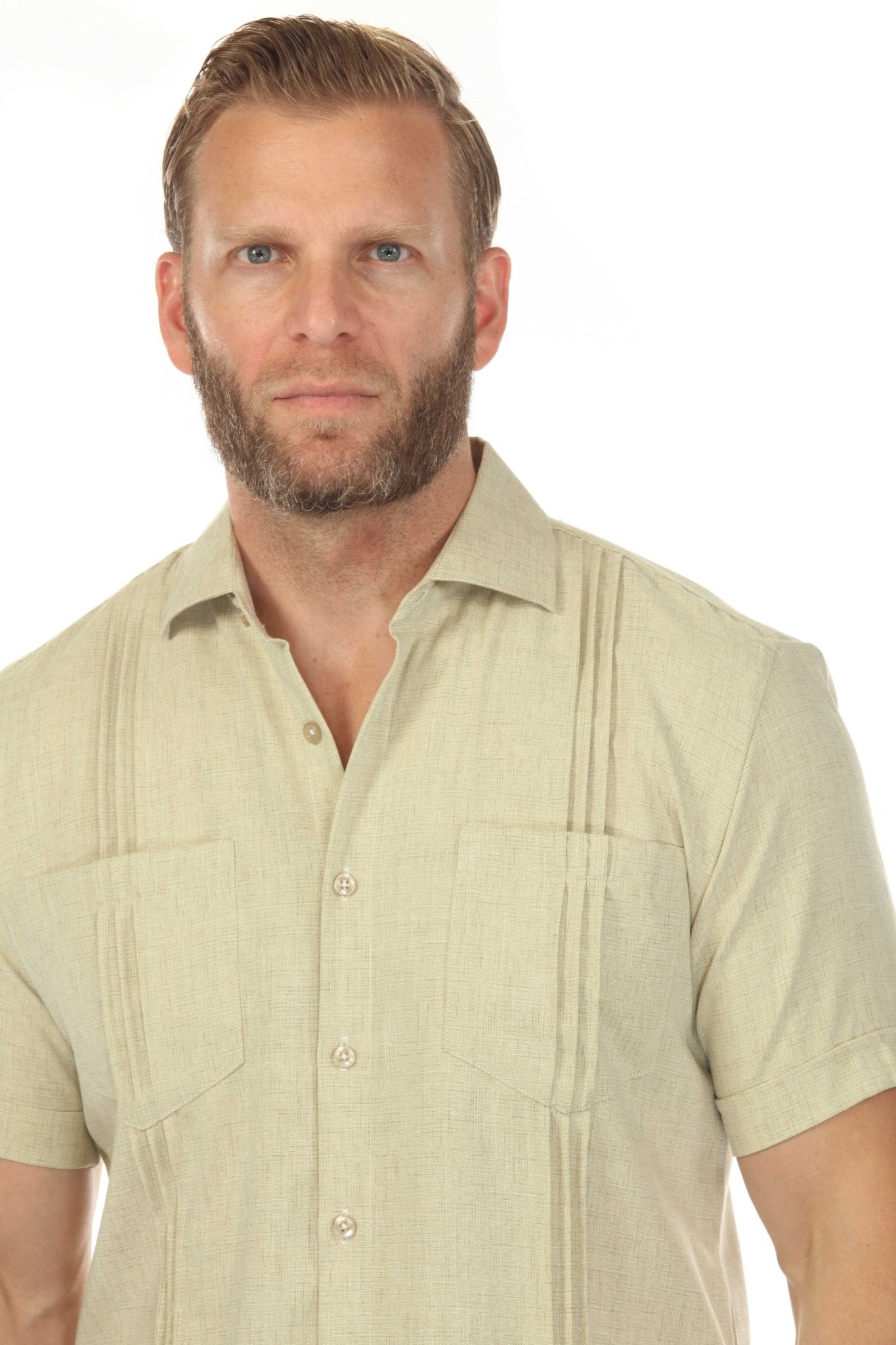 Close-up of a man wearing a light-tan Men’s Classic Two-Pocket Guayamisa Shirt with Pleats.
