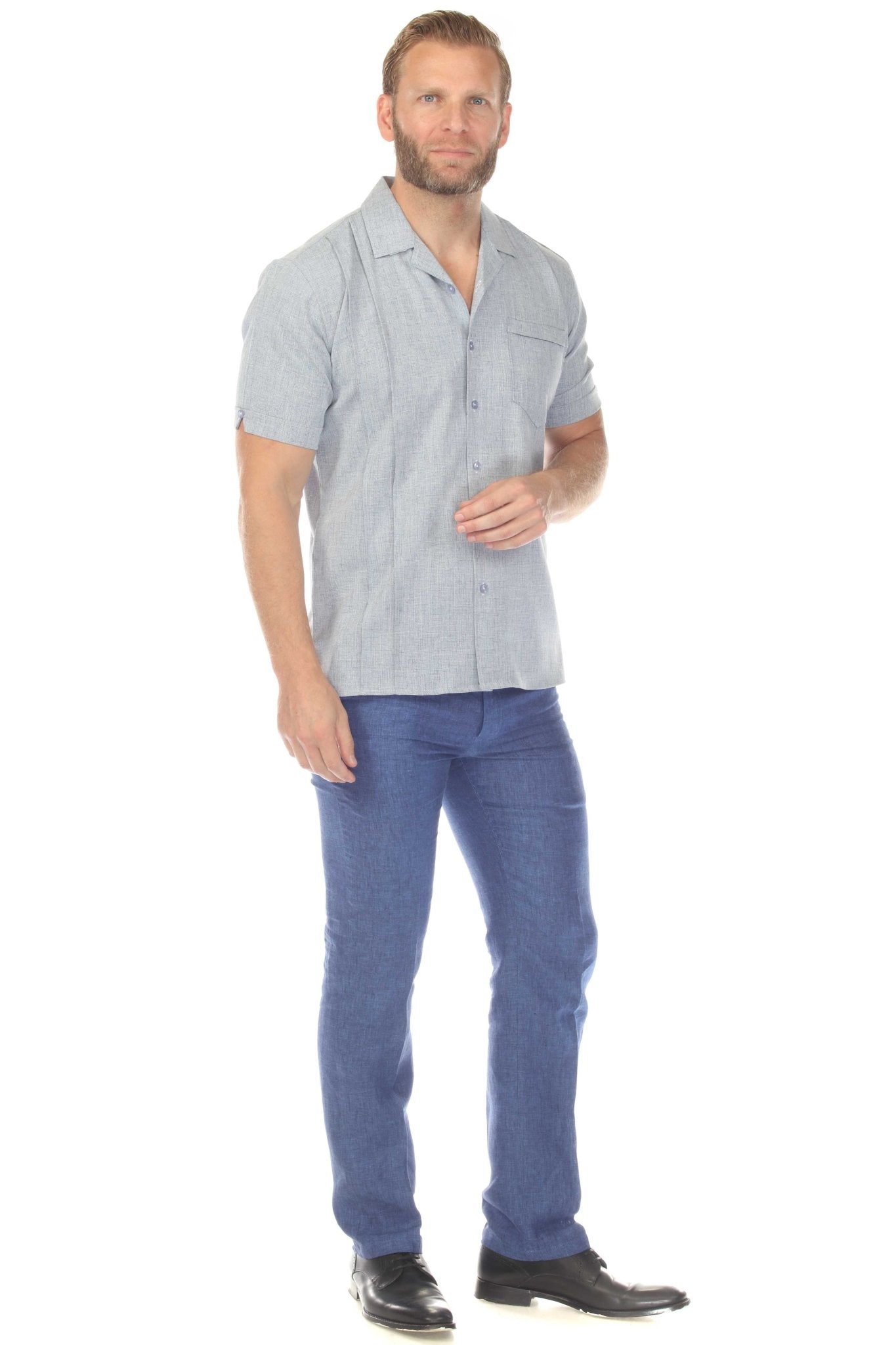 A man wearing a light blue Menâ€™s Retro Cuban Shirt with Pleating, shown full length with blue pants.