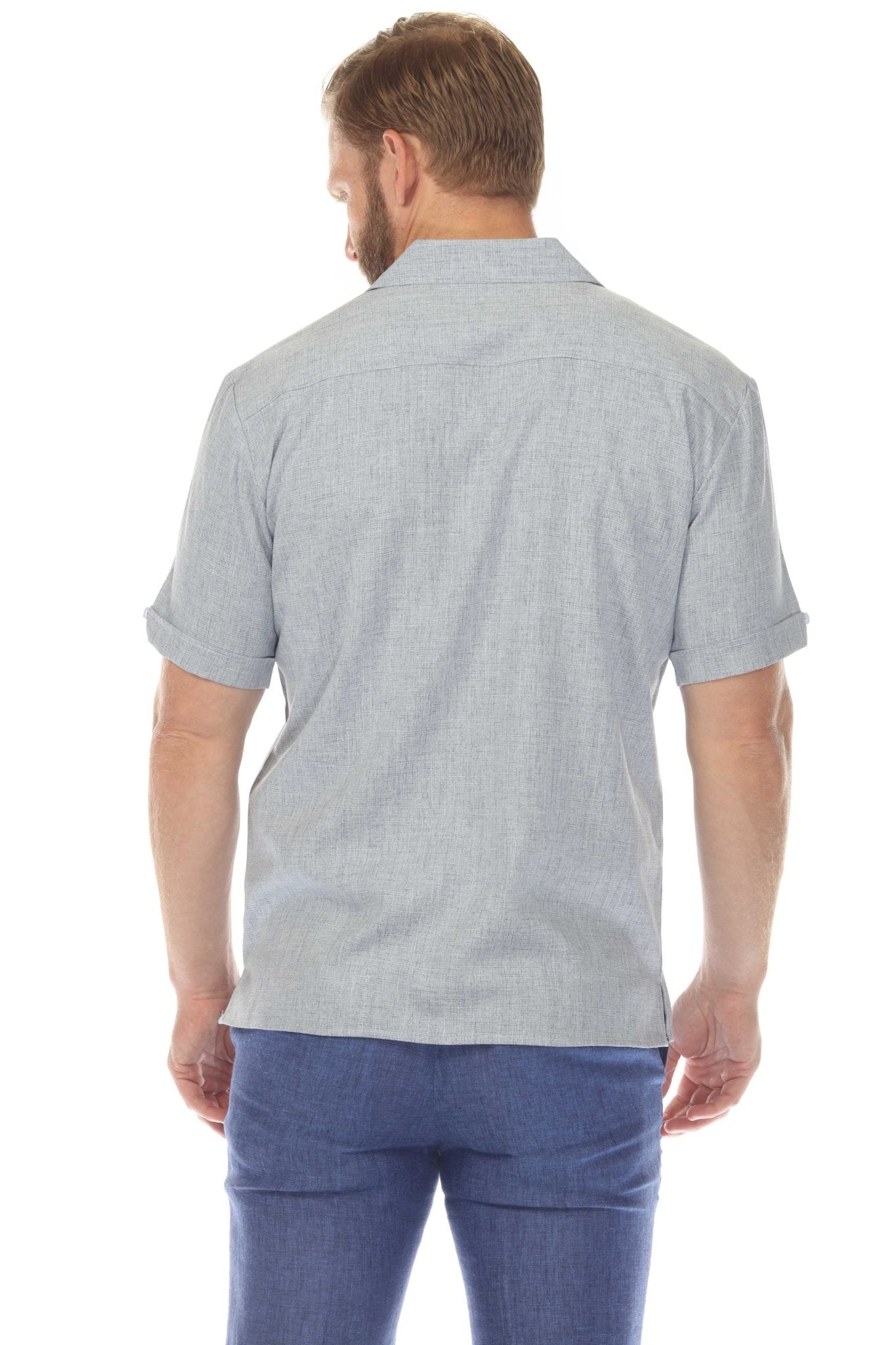 Back view of a man wearing a grey Menâ€™s Retro Cuban Shirt with Pleating and blue pants.