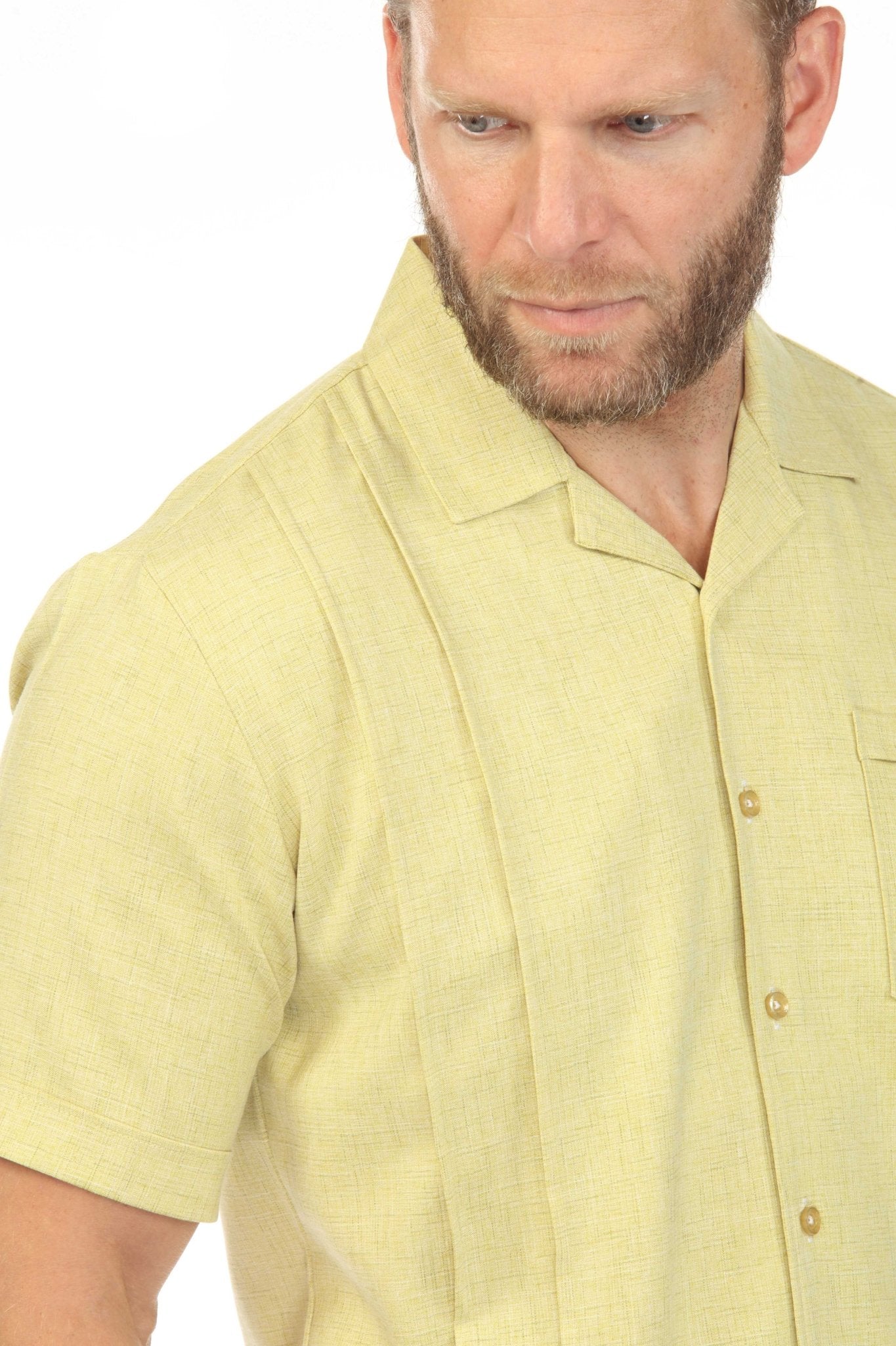 Close-up of a man wearing a light yellow Menâ€™s Retro Cuban Shirt with pleating detail and a single pocket.