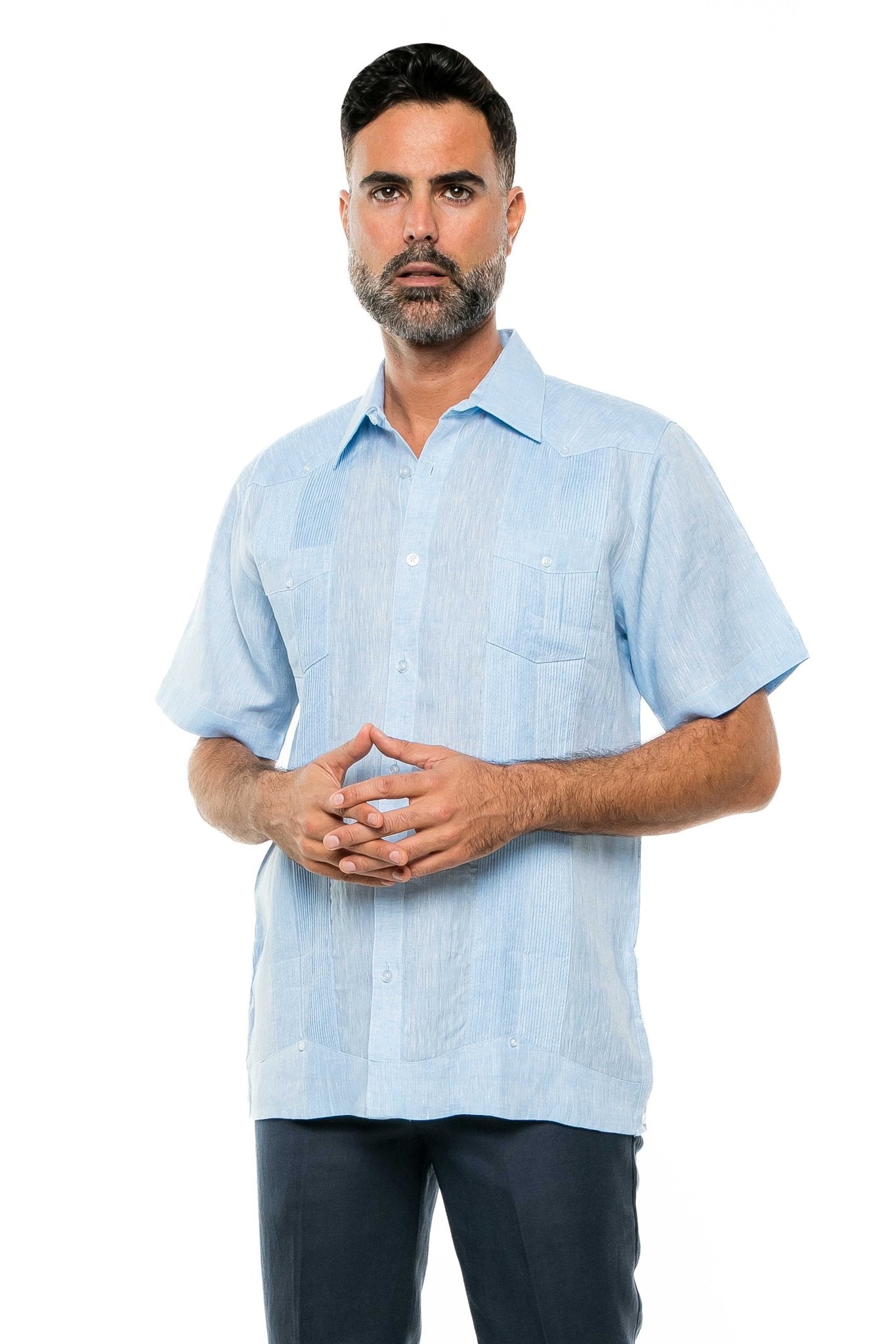 A man wearing a light blue Yarn Dye 100% Linen Two Pocket Guayabera Short Sleeve shirt smiles at the camera.