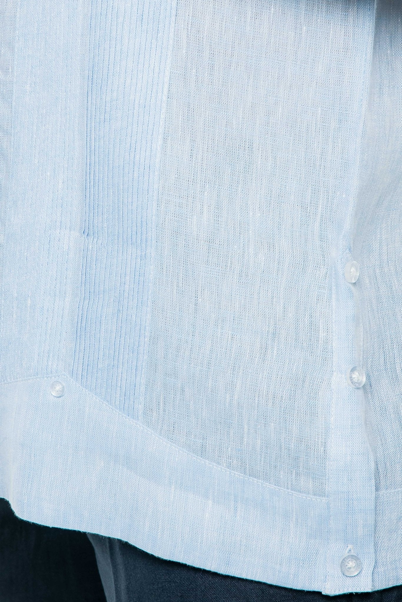 Close-up of the light blue yarn dye 100% linen two pocket guayabera shirt showing the fabric texture and buttons.