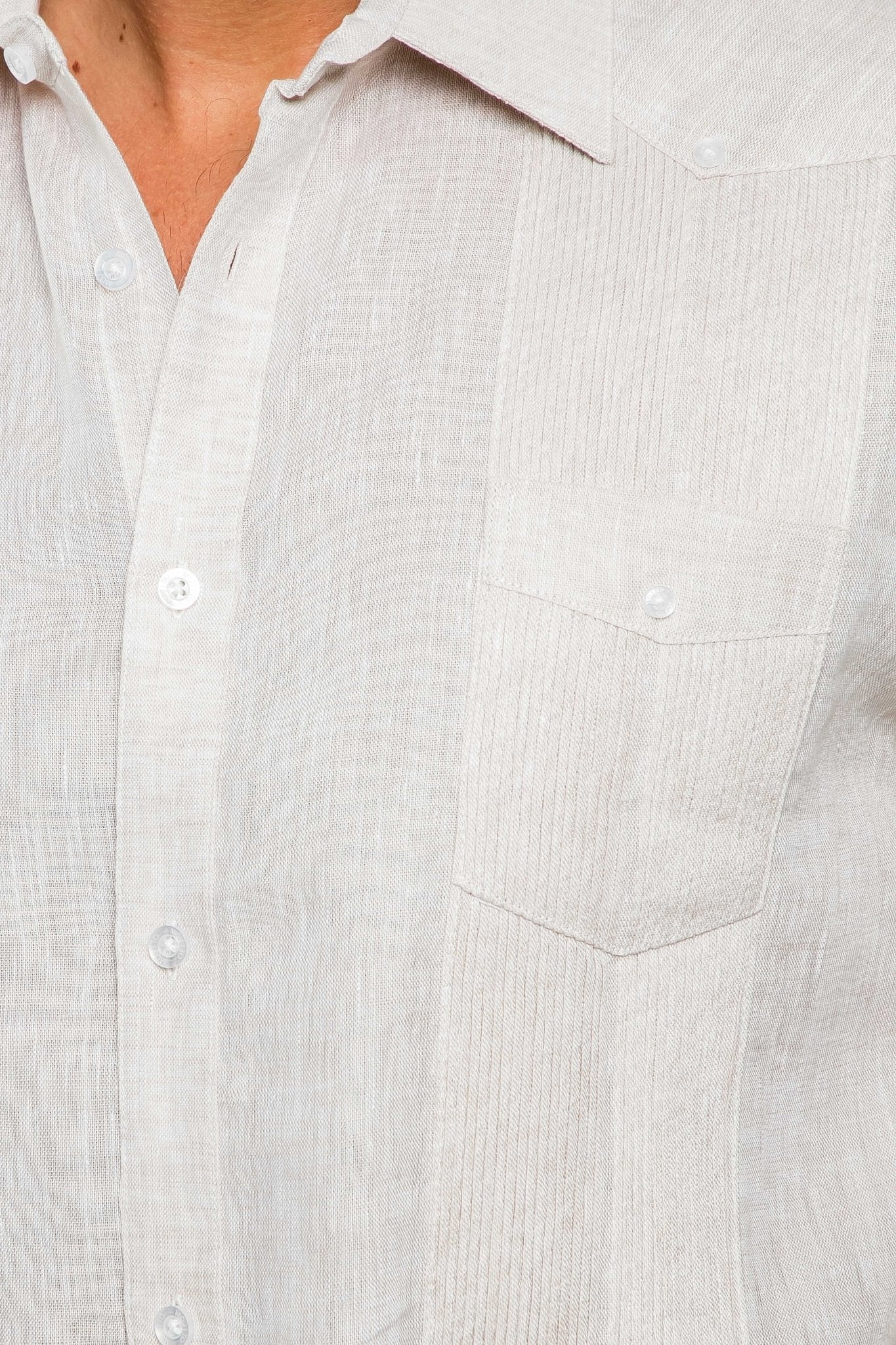 Close-up of a sand-colored Yarn Dye 100% Linen Two Pocket Guayabera shirt, showing the button placket and pocket.
