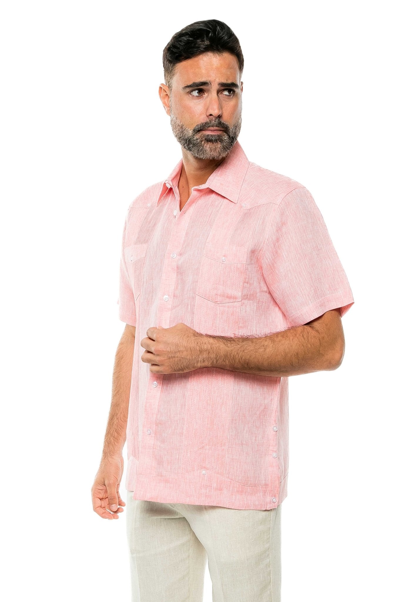 Man wearing a pink yarn dye 100% linen two pocket guayabera short sleeve shirt, shown at a slight angle.