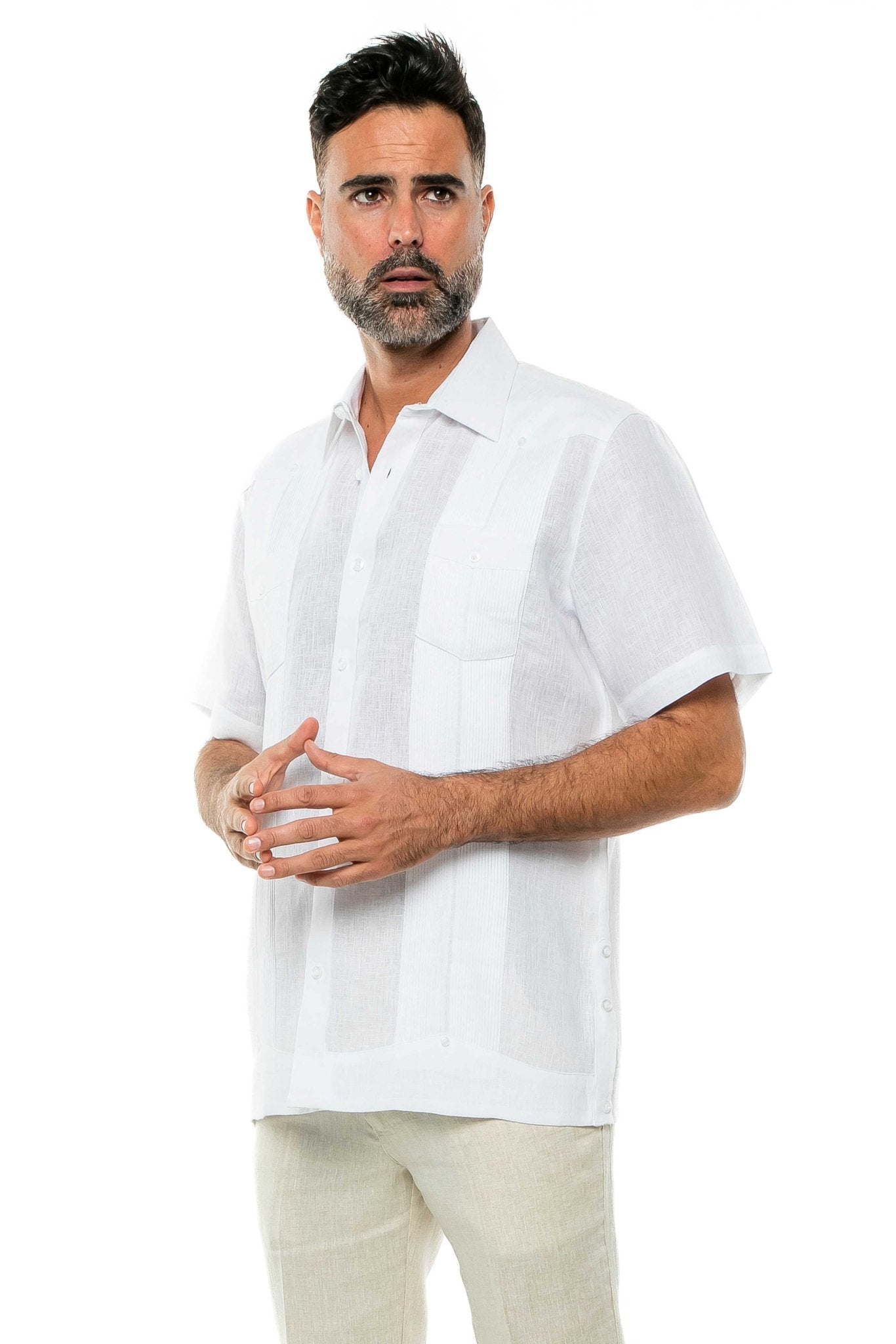 Man wearing a white, short-sleeved, two-pocket Yarn Dye 100% Linen Guayabera shirt buttoned-up, with light tan pants.