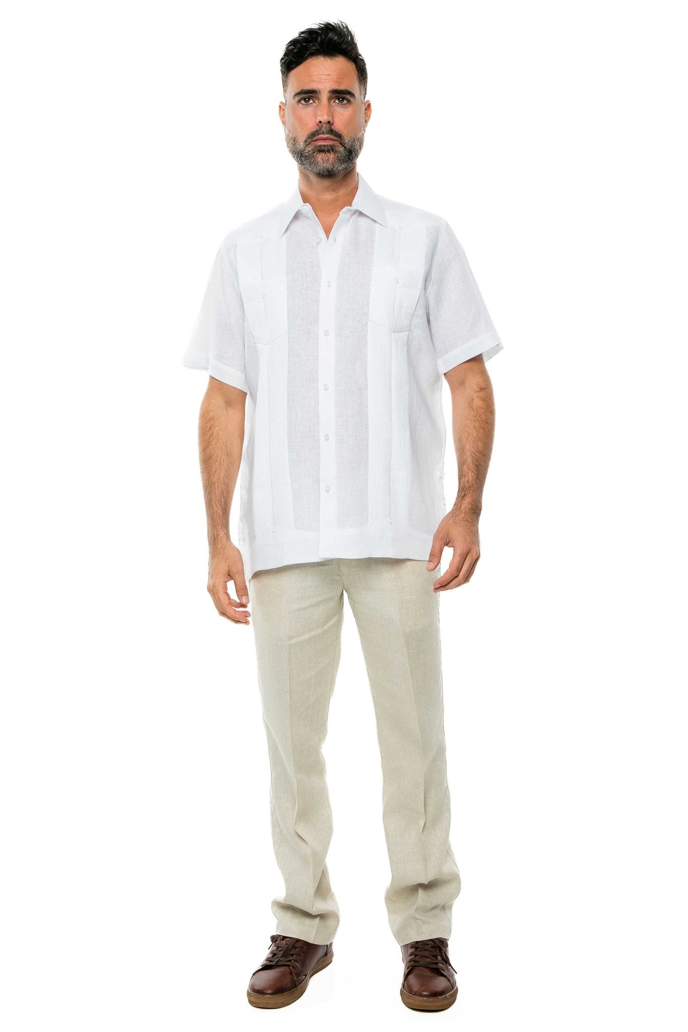 Front view of a man wearing the white yarn dye 100% linen two pocket guayabera short sleeve shirt with light-colored pants.