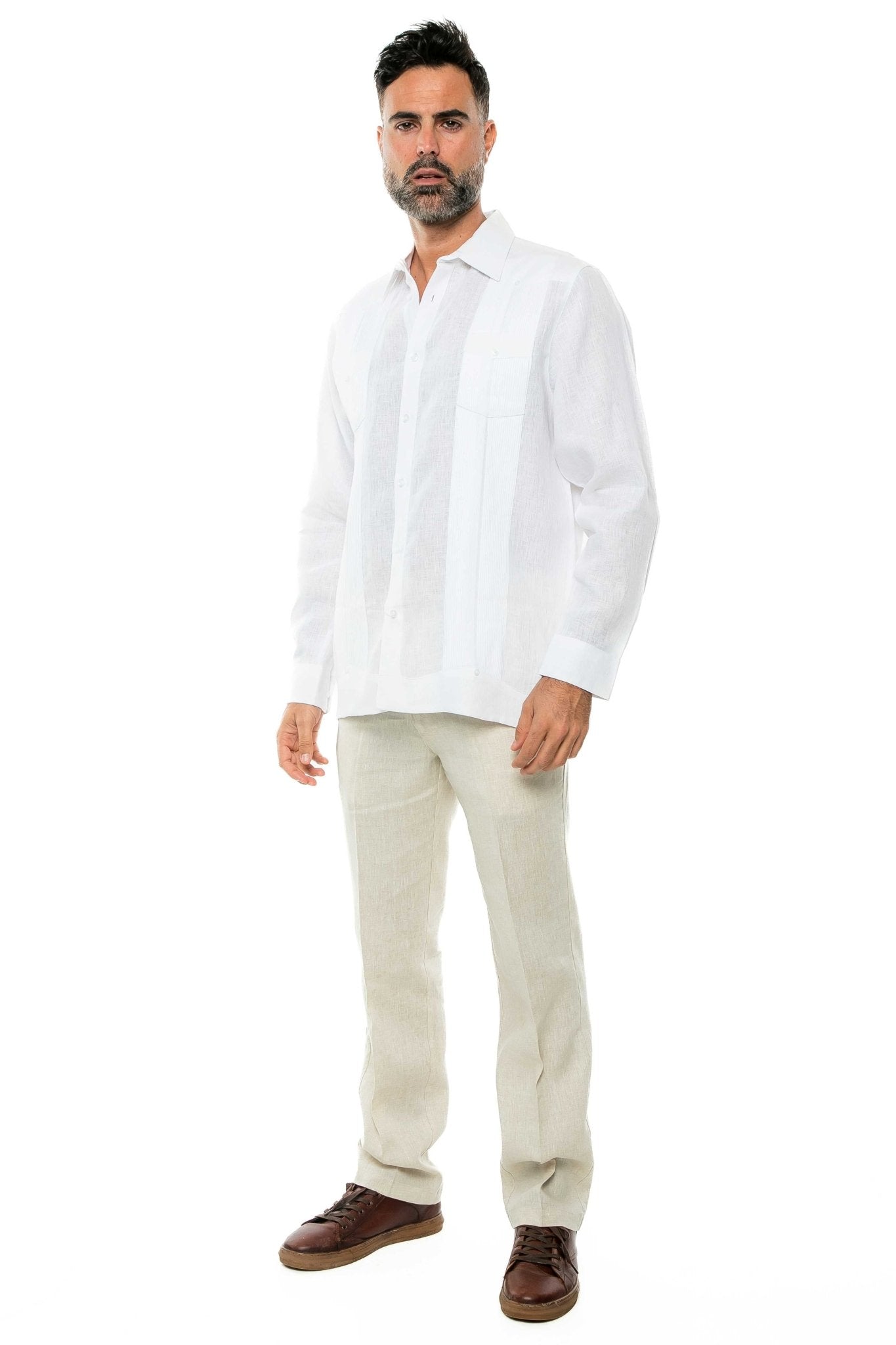 A man wears a white 100% Linen Yarn Dyed Two Pocket Guayabera Shirt with beige linen pants.