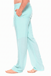 A side profile view of a person wearing light mint green lounge pants with side pockets and a drawstring waist, shown against a plain white background.
