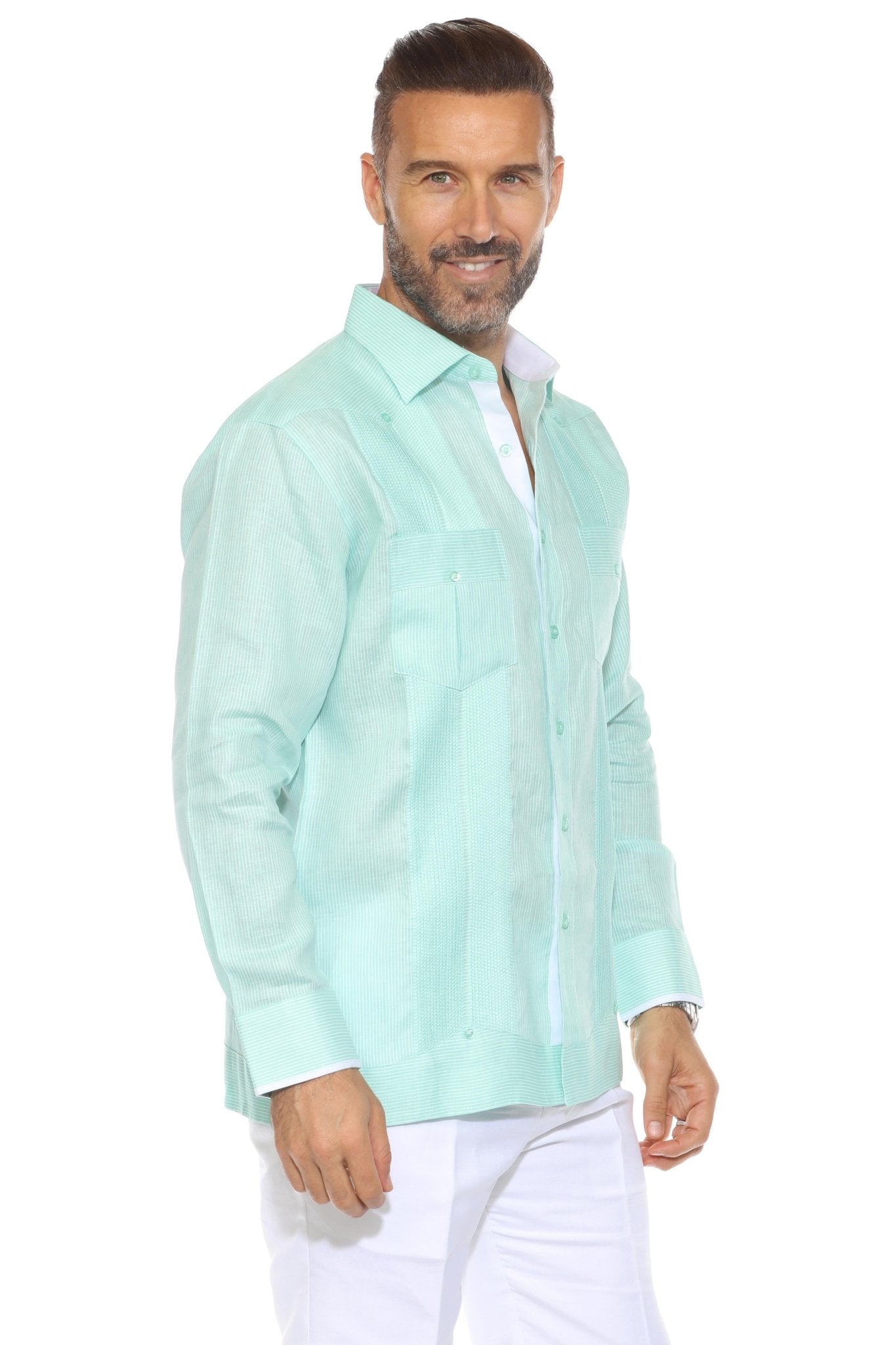 A man smiles wearing a long-sleeved, aqua, 100% Linen Contrast Panel Guayabera Shirt with front pockets and light trim.