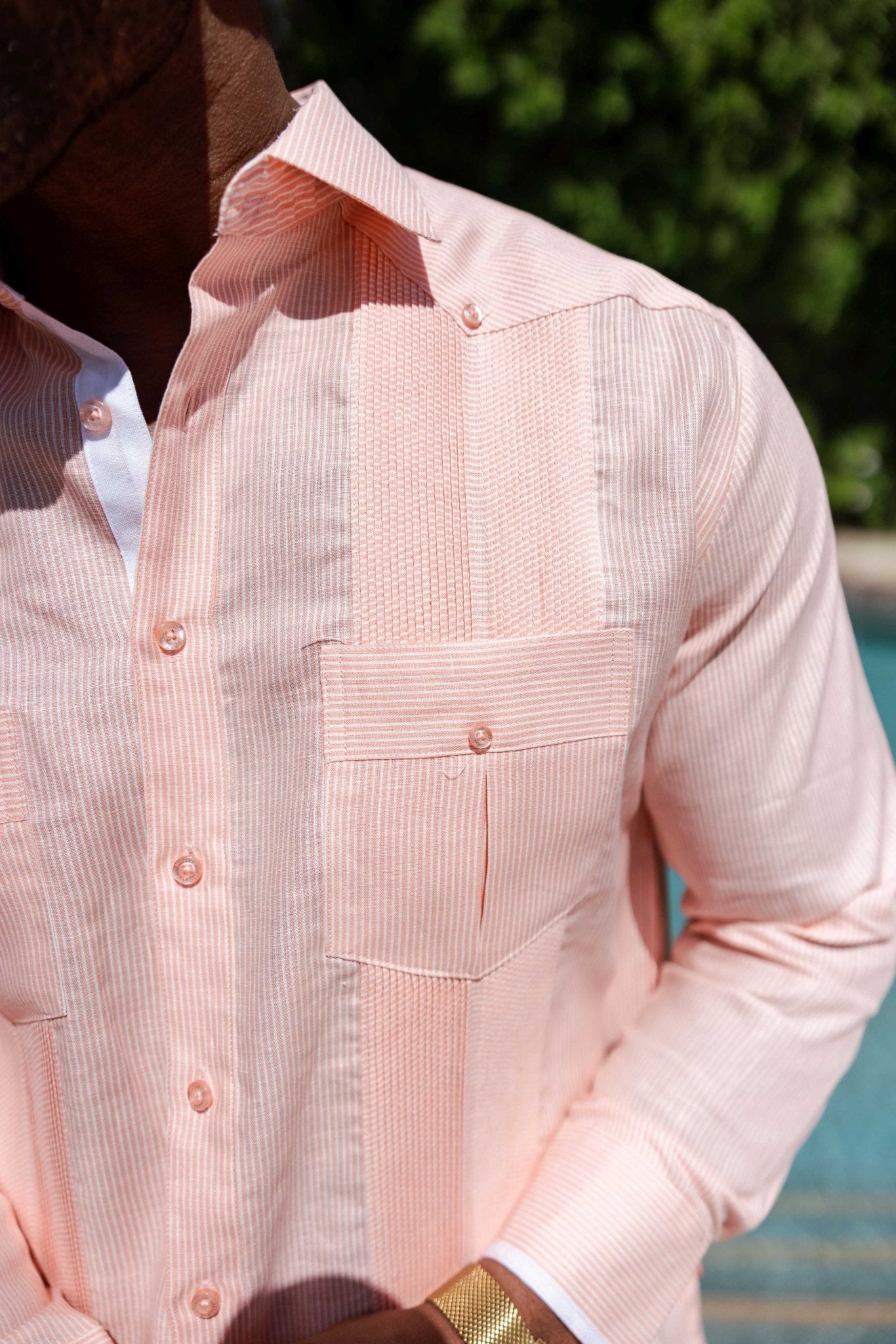 Close-up of a light orange 100% Linen Contrast Panel Guayabera Shirt Long Sleeve, showing the buttoned pocket and textured panels.