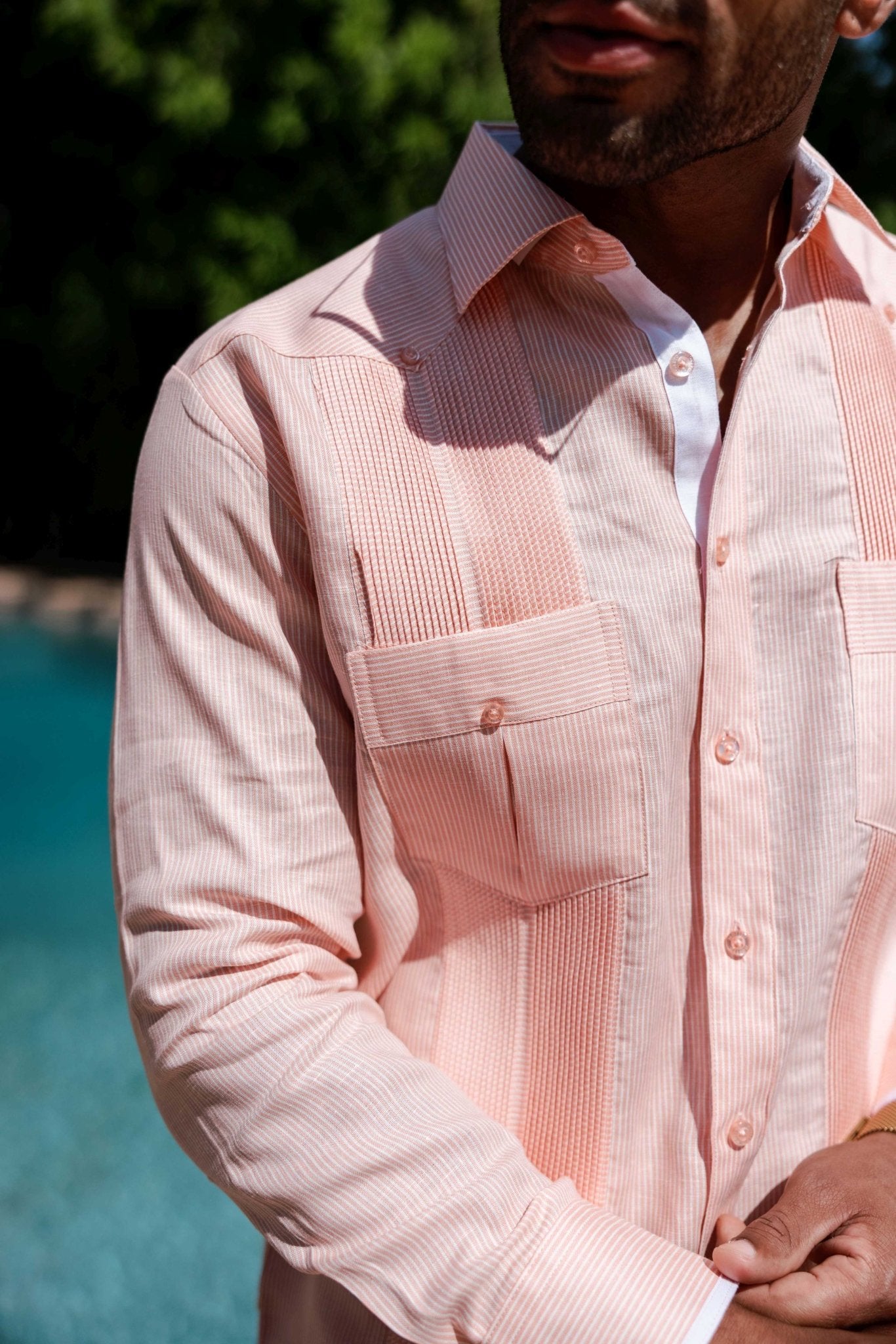 Close-up of a pink striped 100% Linen Contrast Panel Guayabera Shirt Long Sleeve with detailed panels and chest pockets.