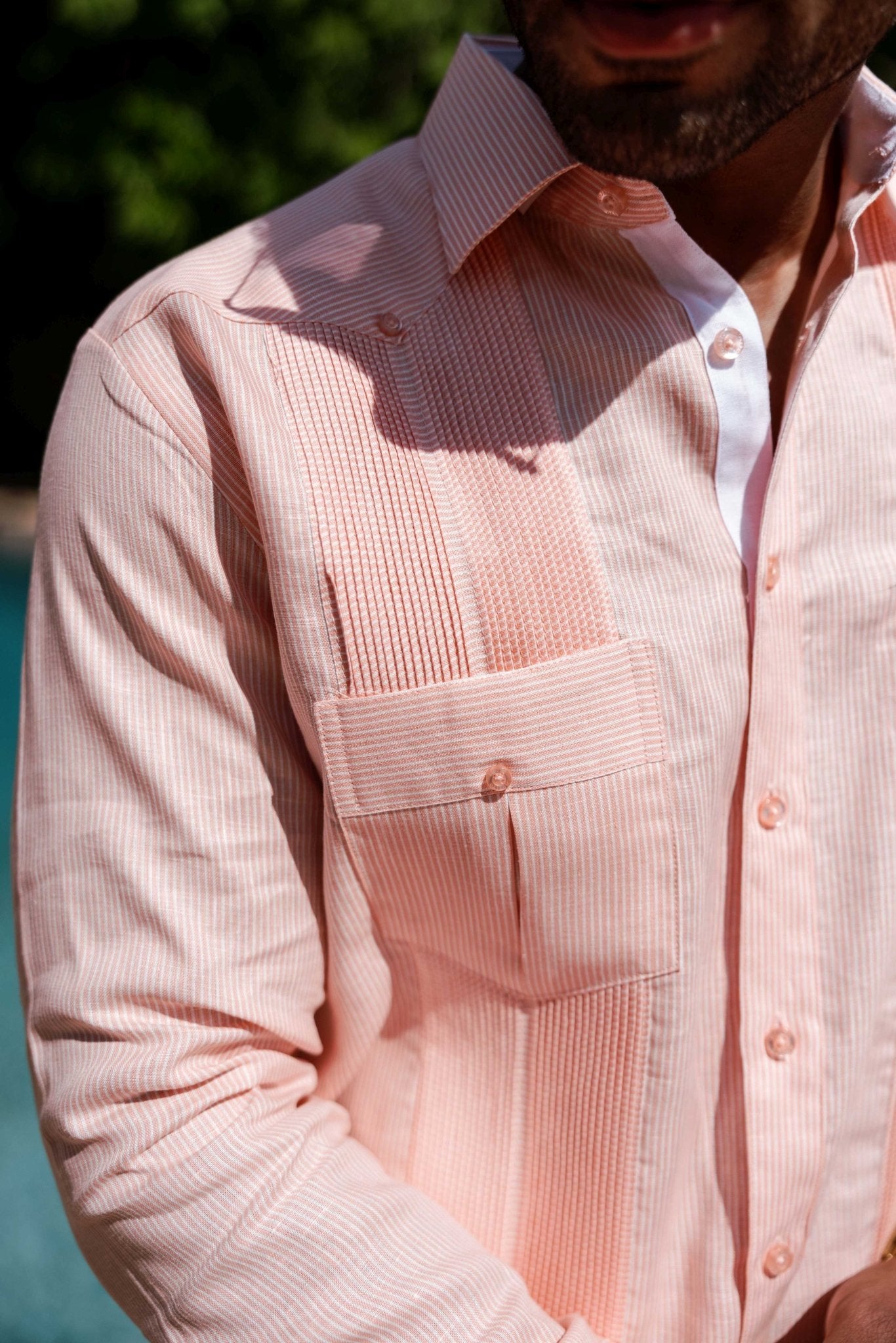 Close up of a light pink, long sleeve 100% Linen Contrast Panel Guayabera Shirt with a white collar and vertical stripes.