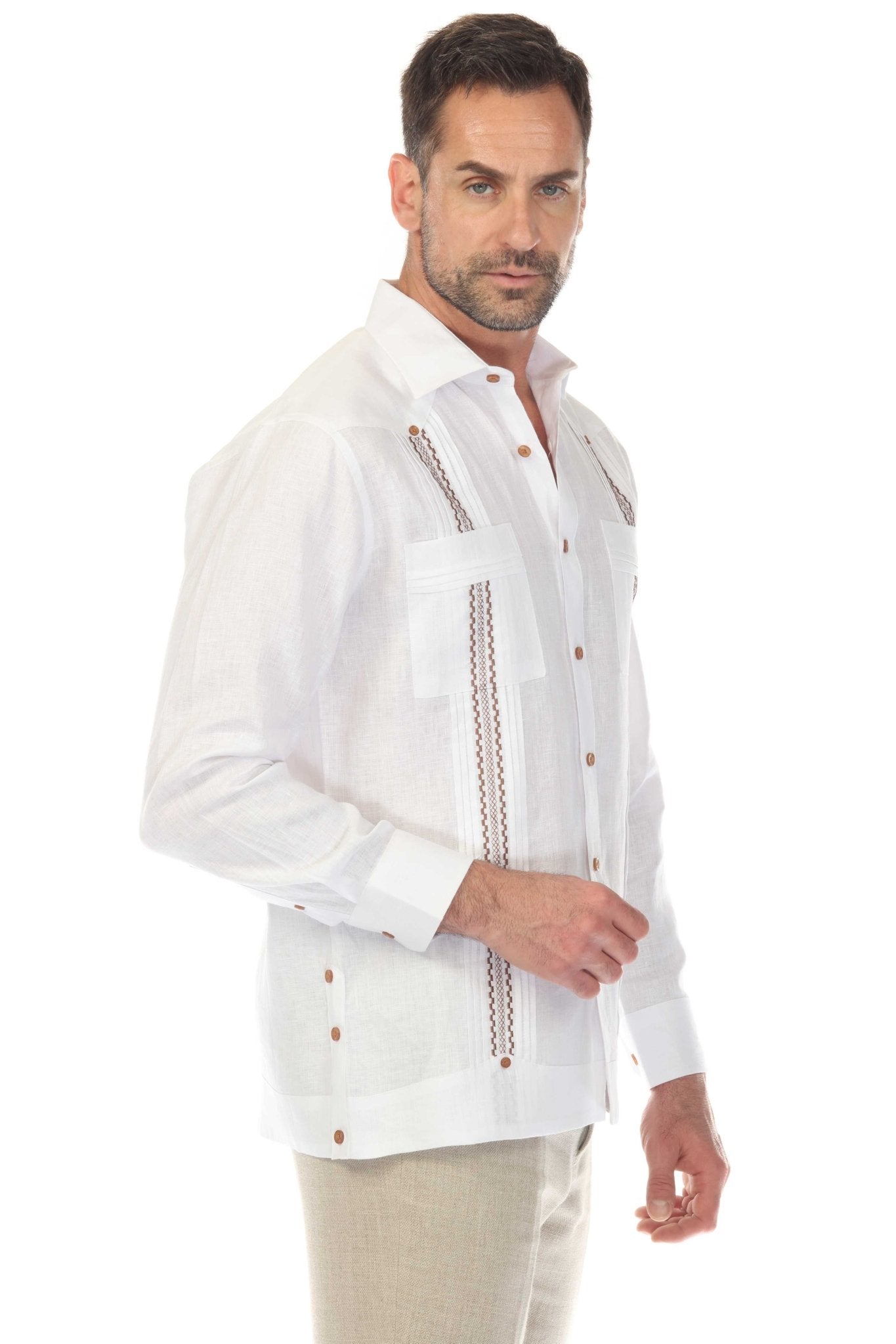A man wears the white, long-sleeve 100% Linen Embroidery Trimmed Guayabera, showing its decorative front detail.