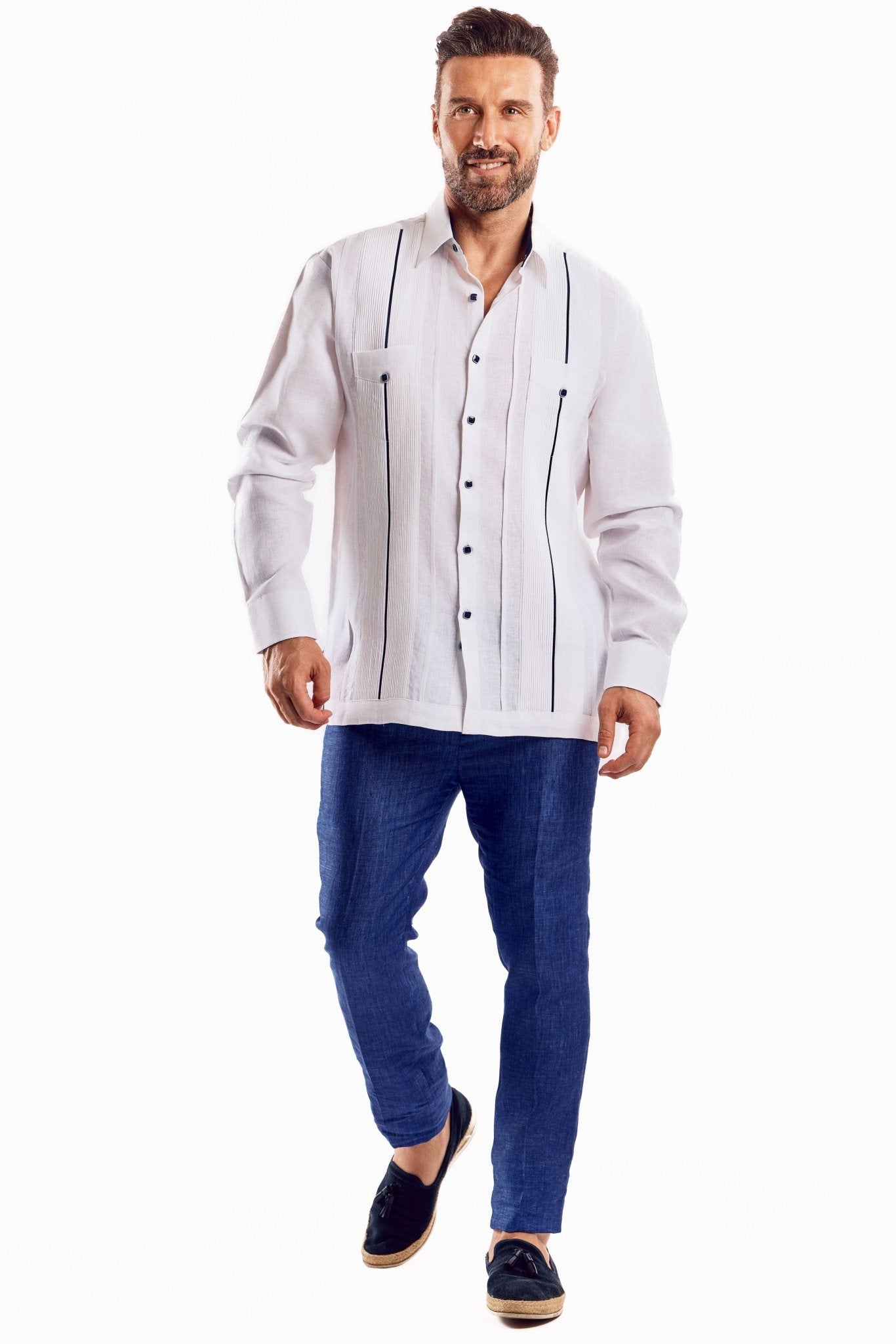A man models a white, long-sleeved Men's Linen Plus Size Guayabera Shirt with dark contrast trim going down the front.