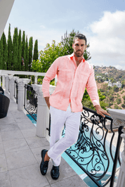 Men's salmon linen embroidered guayabera long sleeve with white linen pants and loafers on a balcony by the pool