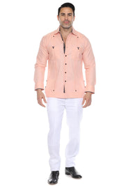 A full body shot of a man wearing a peach Men’s Long Sleeve Linen Guayabera Shirt with white linen pants and black shoes, perfect for a tropical wedding or beach formal event.