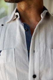 Macro view of the white Men's Long Sleeve Linen Guayabera Shirt showcasing the vibrant blue printed trim inside the collar and the classic pleated front