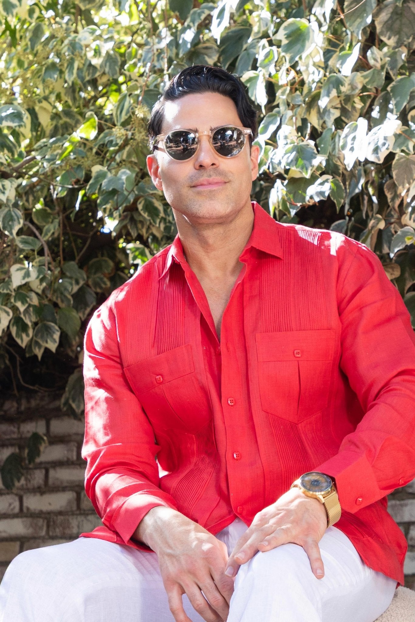 A man in a red Yarn Dyed Linen Guayabera with pleats and two pockets.