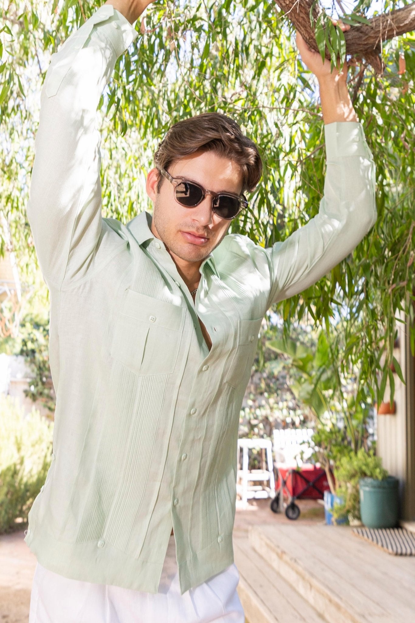 Front view of a man wearing the light green Yarn Dyed Linen Guayabera shirt, with multi pleats and two pockets.