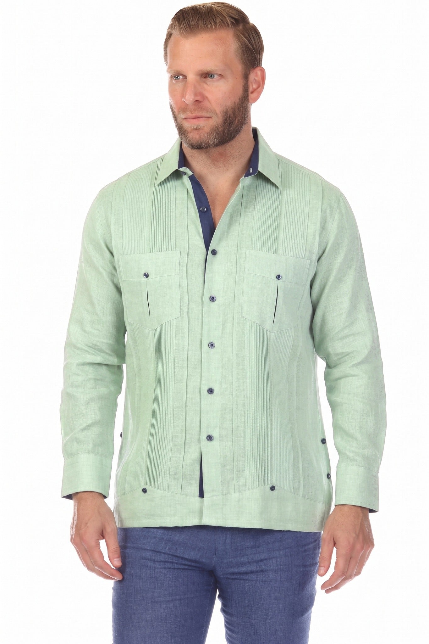 A man wears the sage green 100% Linen Contrast Panel Guayabera Shirt Long Sleeve with navy accents, looking to the side.