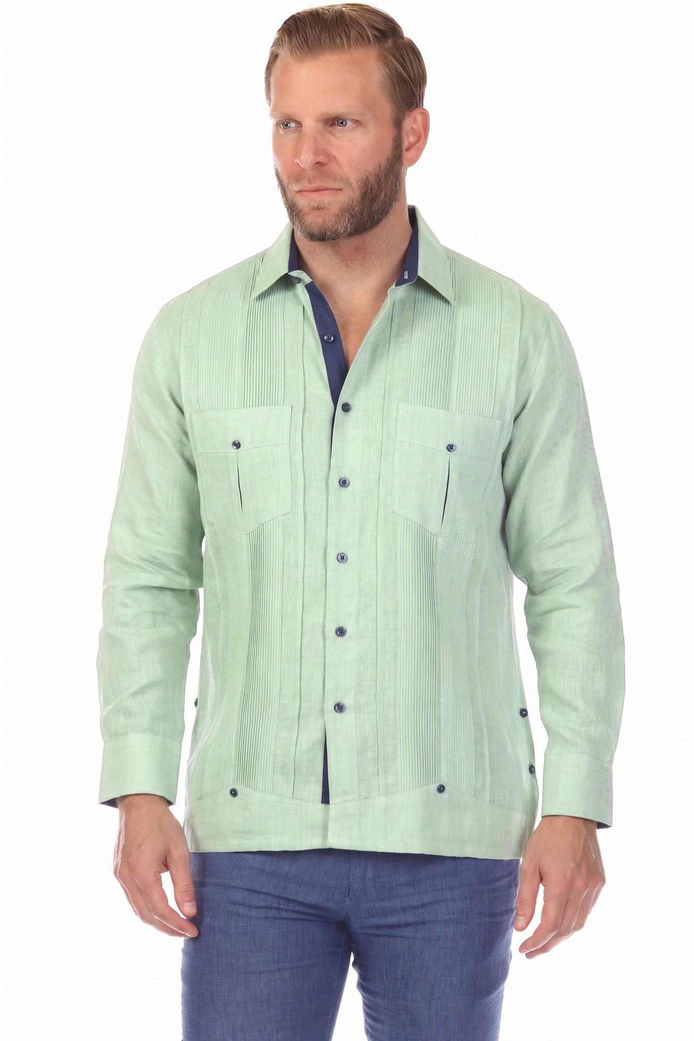 A man wears the sage green 100% Linen Contrast Panel Guayabera Shirt Long Sleeve with navy accents, looking to the side.