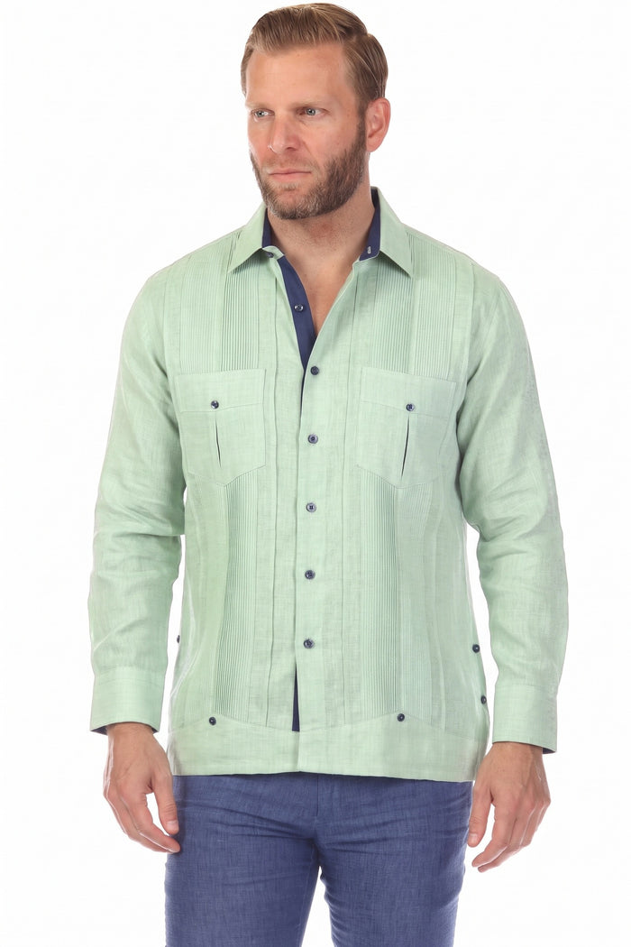 Man wearing the pink 100% Linen Contrast Panel Guayabera Shirt with long sleeves and blue accents, seated in a wicker chair.