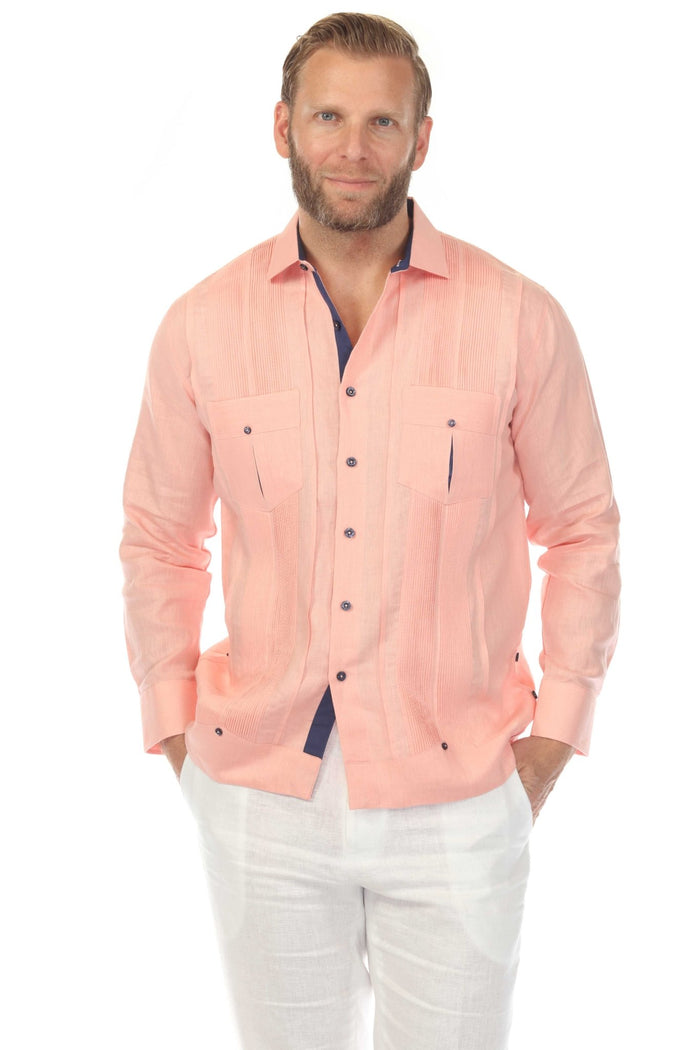 Man wearing the pink 100% Linen Contrast Panel Guayabera Shirt with long sleeves and blue accents, seated in a wicker chair.