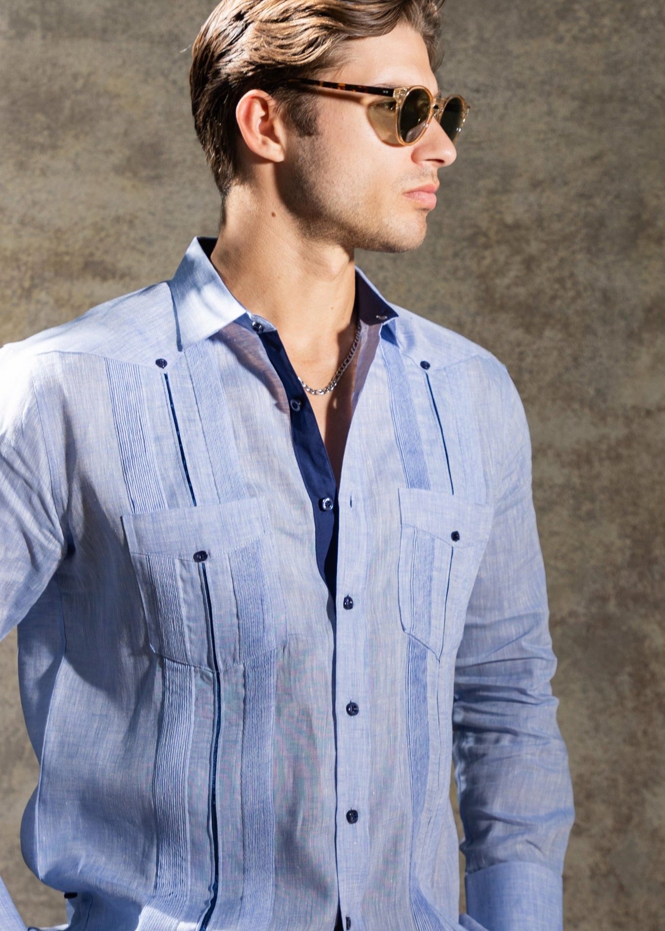 Man wearing a light blue 100% Linen Guayabera, shown with satin taping and two pockets.