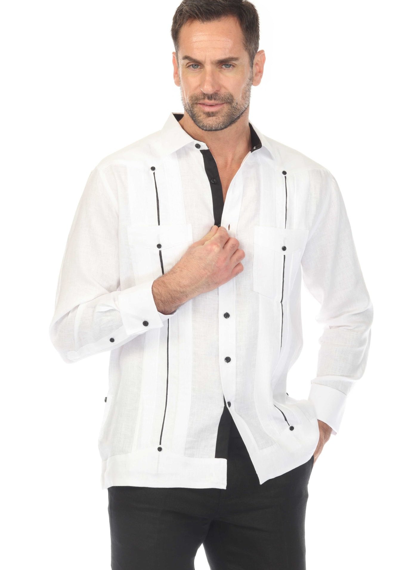 Man wearing the white linen guayabera shirt with contrast taping and french cuffs, partially buttoned.