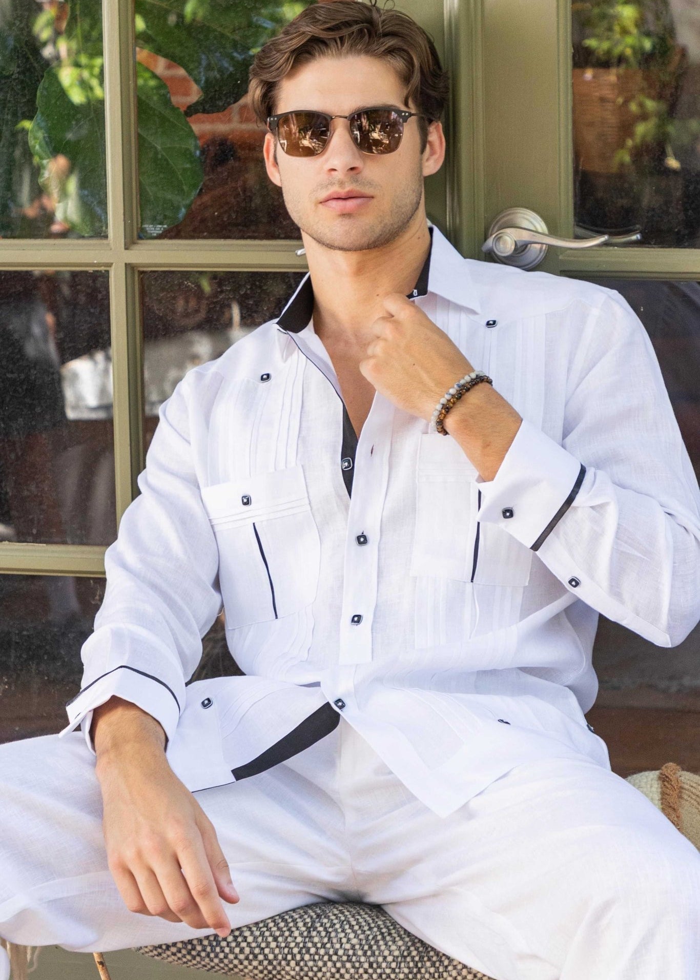 Man in a white Men's Premium Linen Guayabera shirt with wide pleating and contrast detail.