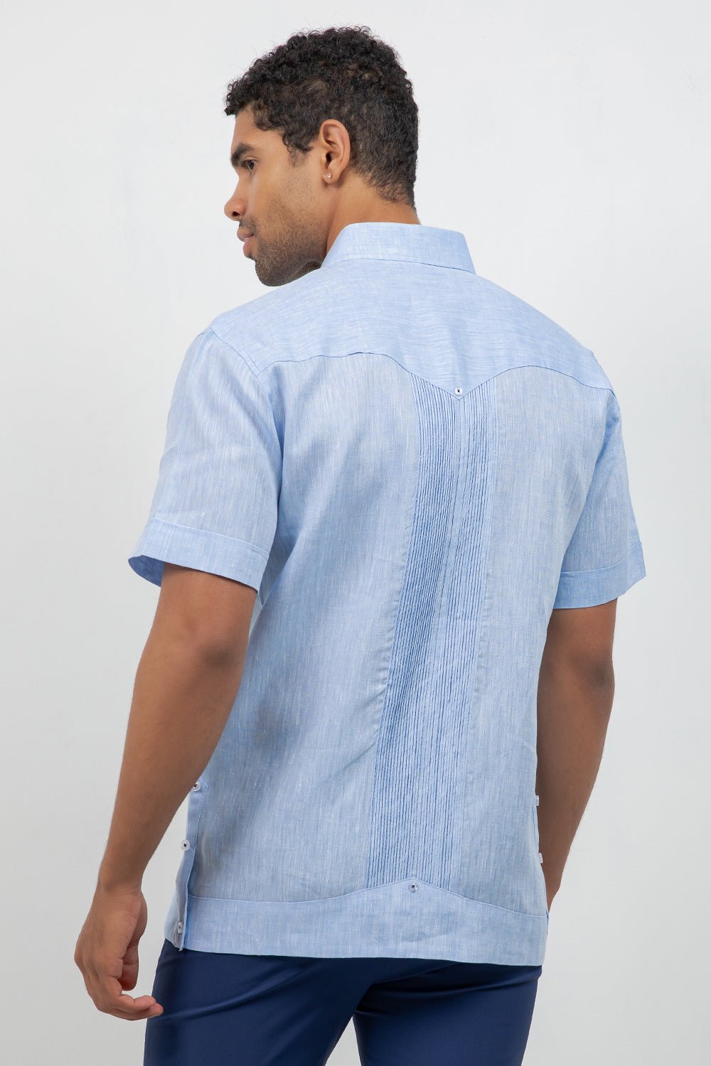 Man wearing a light blue short-sleeve shirt on a white background