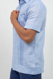 Person wearing a light blue striped shirt with short sleeves on a plain background