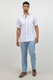 Man wearing a white short-sleeve shirt and light blue pants on a white background