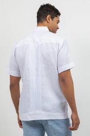 Man wearing a white short-sleeve shirt with a subtle pattern on a plain background