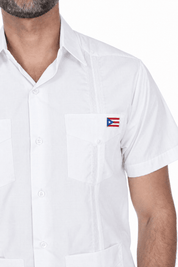 Close-up of the white Limited Edition guayabera showing the embroidered Puerto Rico flag patch on the left chest pocket