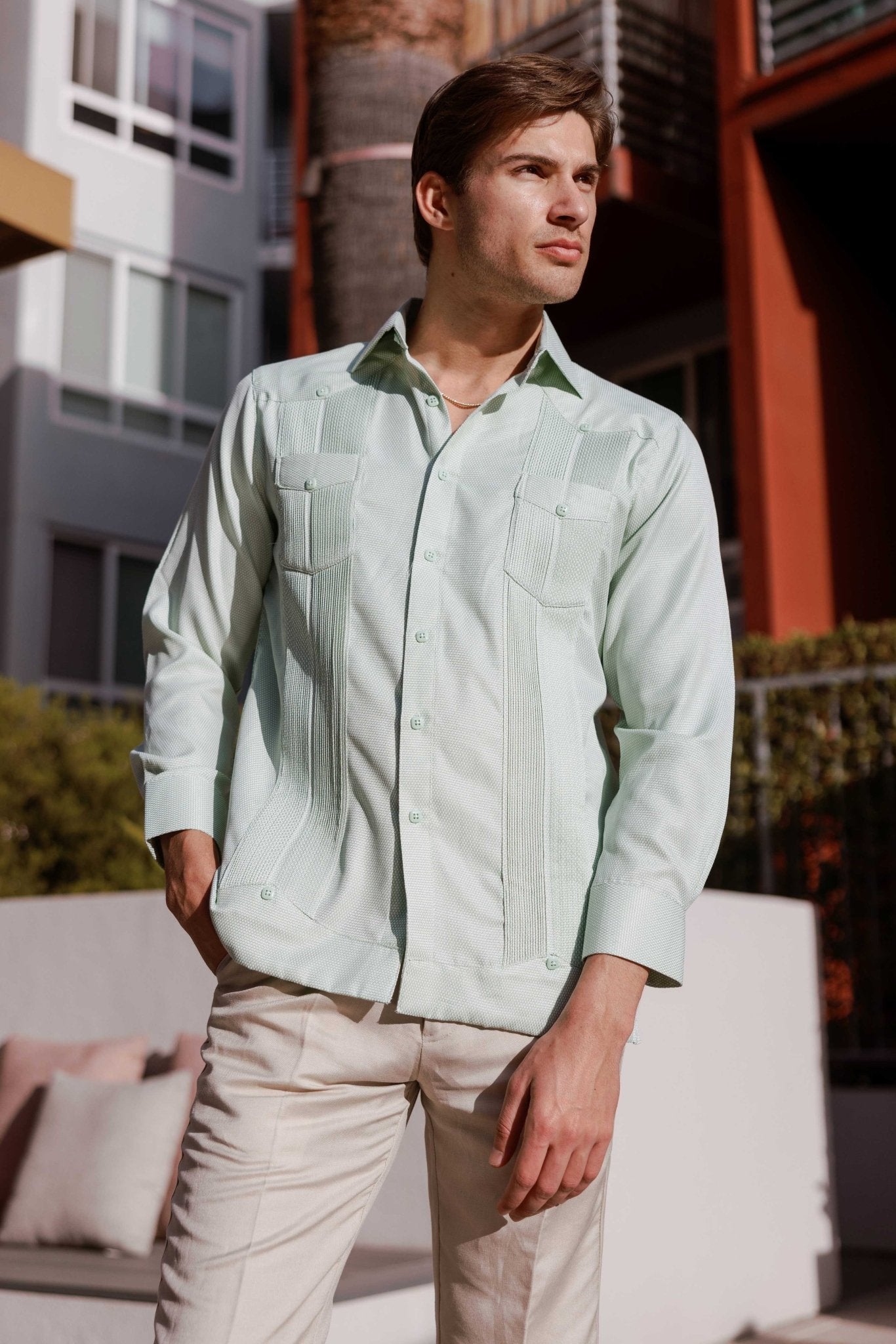 Man wears a Mojito Reserve Men's Two-Pocket Guayabera, shown in light green with diamond texture and two chest pockets.