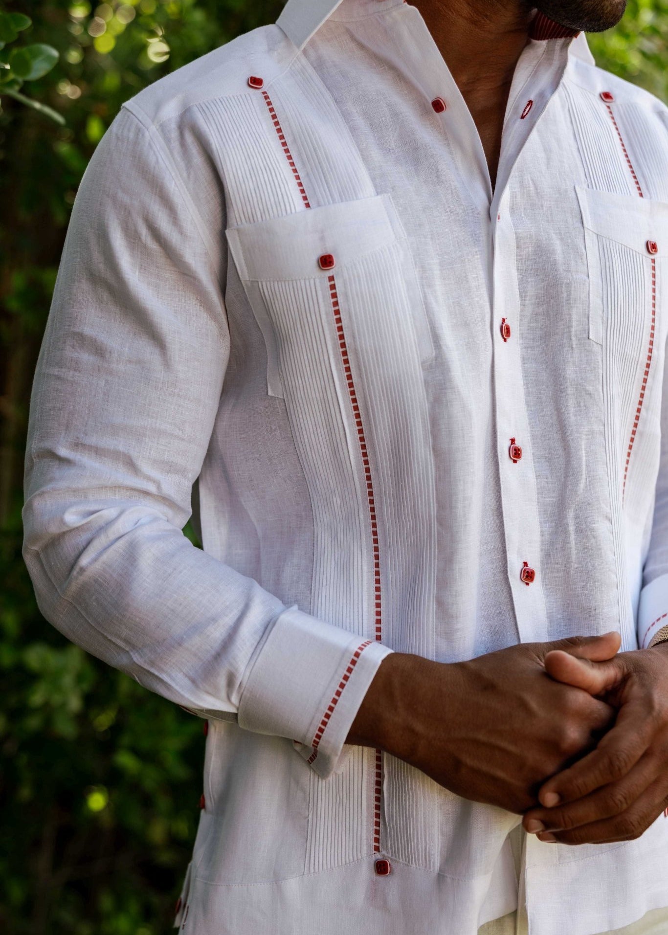 Front view of a long sleeve white linen chacabana-inspired shirt highlighting the French cuffs and vertical pin-tucks.