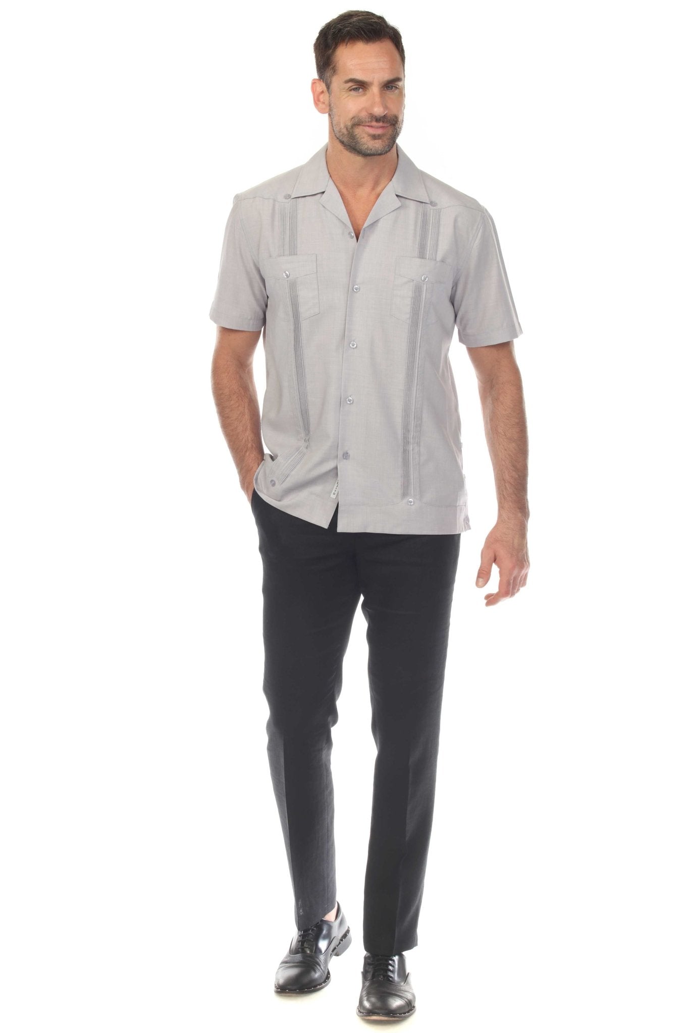 A man wears a light gray Men’s Two-Pocket Cross-Dye Guayamisa Shirt with Pleats, standing forward facing.