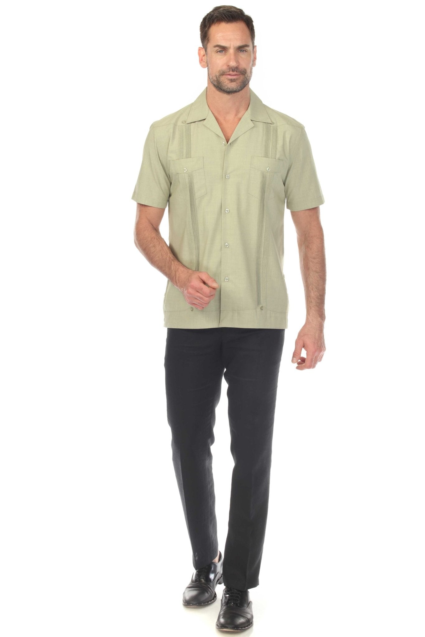 A man models a light green Men’s Two-Pocket Cross-Dye Guayamisa Shirt with Pleats buttoned up and paired with black pants.