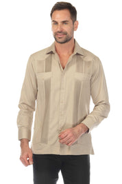 A man wears the tan, long-sleeve, two-pocket Guayabera shirt, buttoned, with pick stitching detail.