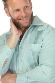 Close up of a smiling man wearing a light blue Men’s Long Sleeve Two-Pocket Guayabera Shirt, showing the pleats.