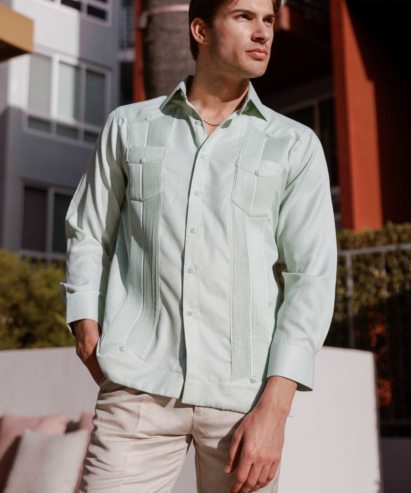 Man wears a Mojito Reserve Men's Two-Pocket Guayabera, shown in light green with diamond texture and two chest pockets.