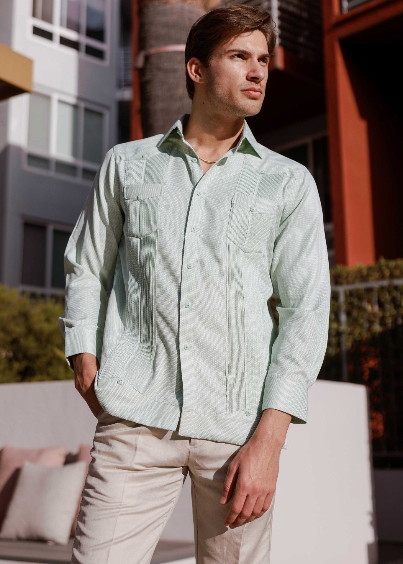 Man wears a Mojito Reserve Men's Two-Pocket Guayabera, shown in light green with diamond texture and two chest pockets.