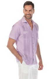 A man models a lavender Men’s Two-Pocket Guayabera Shirt with Micro Textured Print, shown at a slight angle.